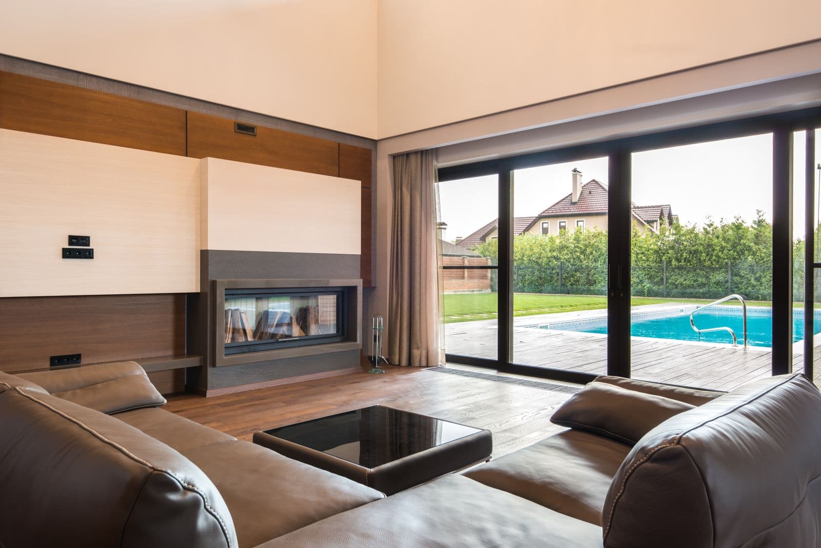 Wide sliding glass doors opening from a living room to a poolside terrace, illustrative product reference